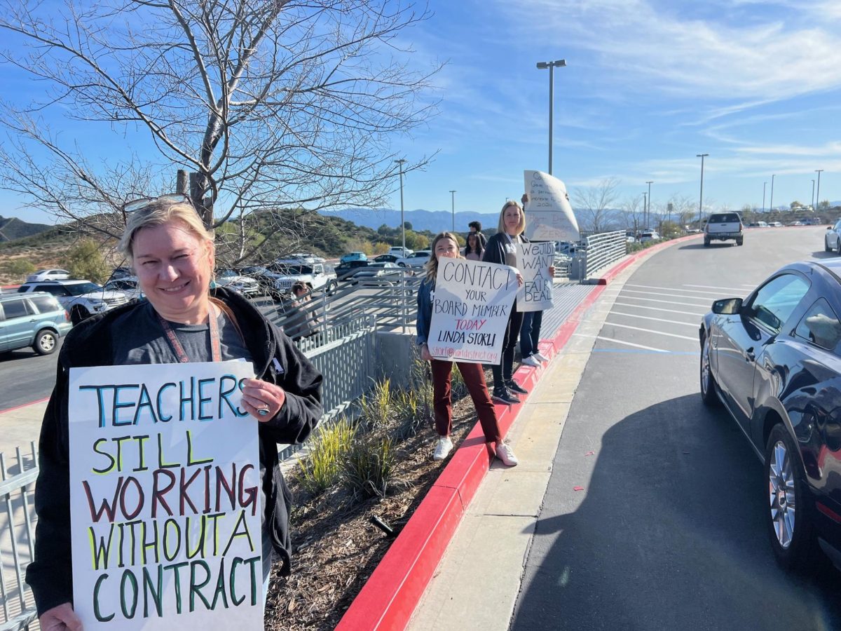 CHS teachers holding up signs in protest during pick-up 