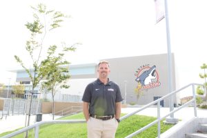 Mr. Wobrock standing in front of the newly painted Castaic Coyotes mural.