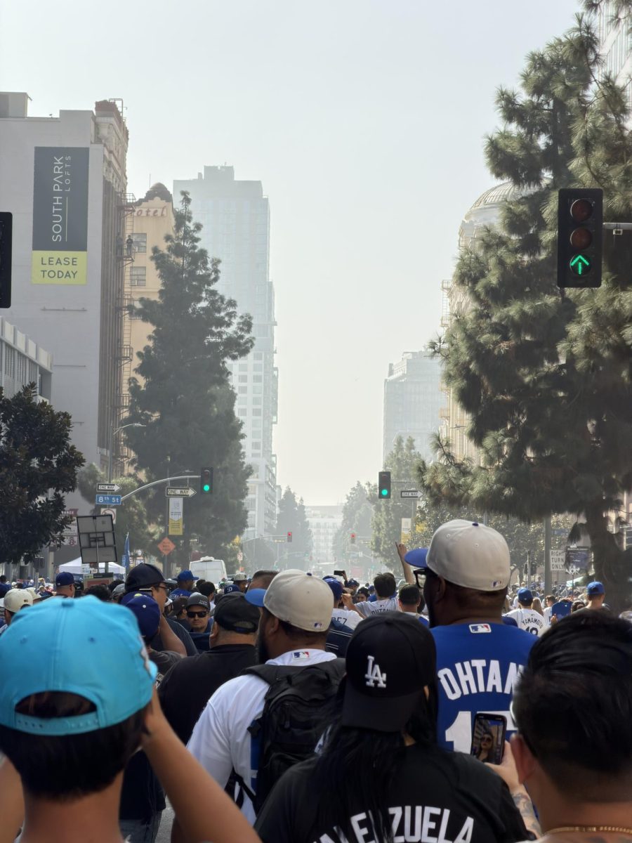 Dodger fans walk through the street after the Dodgers' World Series Parade passes by. 